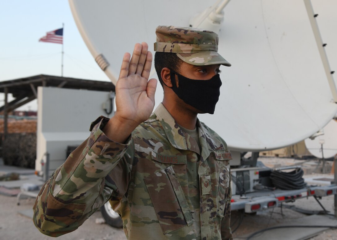 Senior Airman Aron Franks, assigned to the 16th Expeditionary Space Control flight deployed Al Udeid Air Base, Qatar, raises his right hand as he enlists into the U.S. Space Force on Sept. 1, 2020. The Space Force is the United States' newest service in more than 70 years. (U.S. Air Force photo by Staff Sgt. Kayla White)