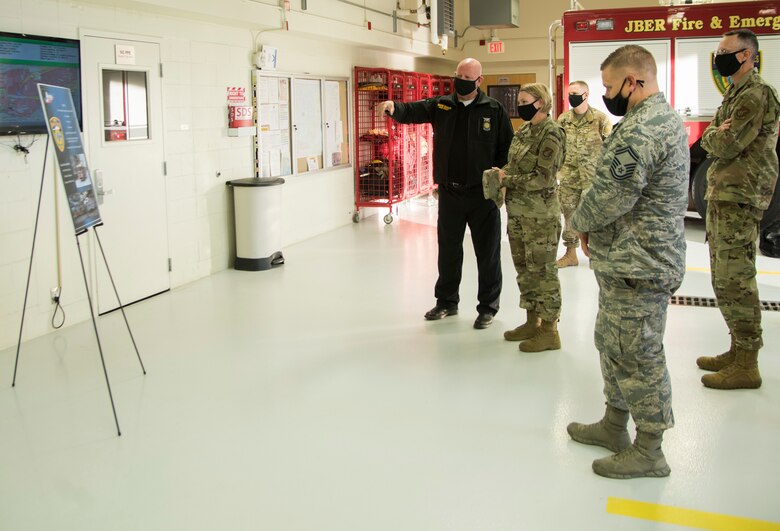 David Donan, 673d Civil Engineer Squadron fire chief, explains how the Joint Base Elmendorf-Richardson Fire and Emergency Services Flight support the 673d Air Base Wing during an immersion tour at JBER, Alaska, Aug. 28, 2020. U.S. Air Force Col. Kirsten Aguilar, JBER and 673d ABW commander, focused on the 673d CES Airmen and their role in supporting the joint base partnership on the installation in her tour.