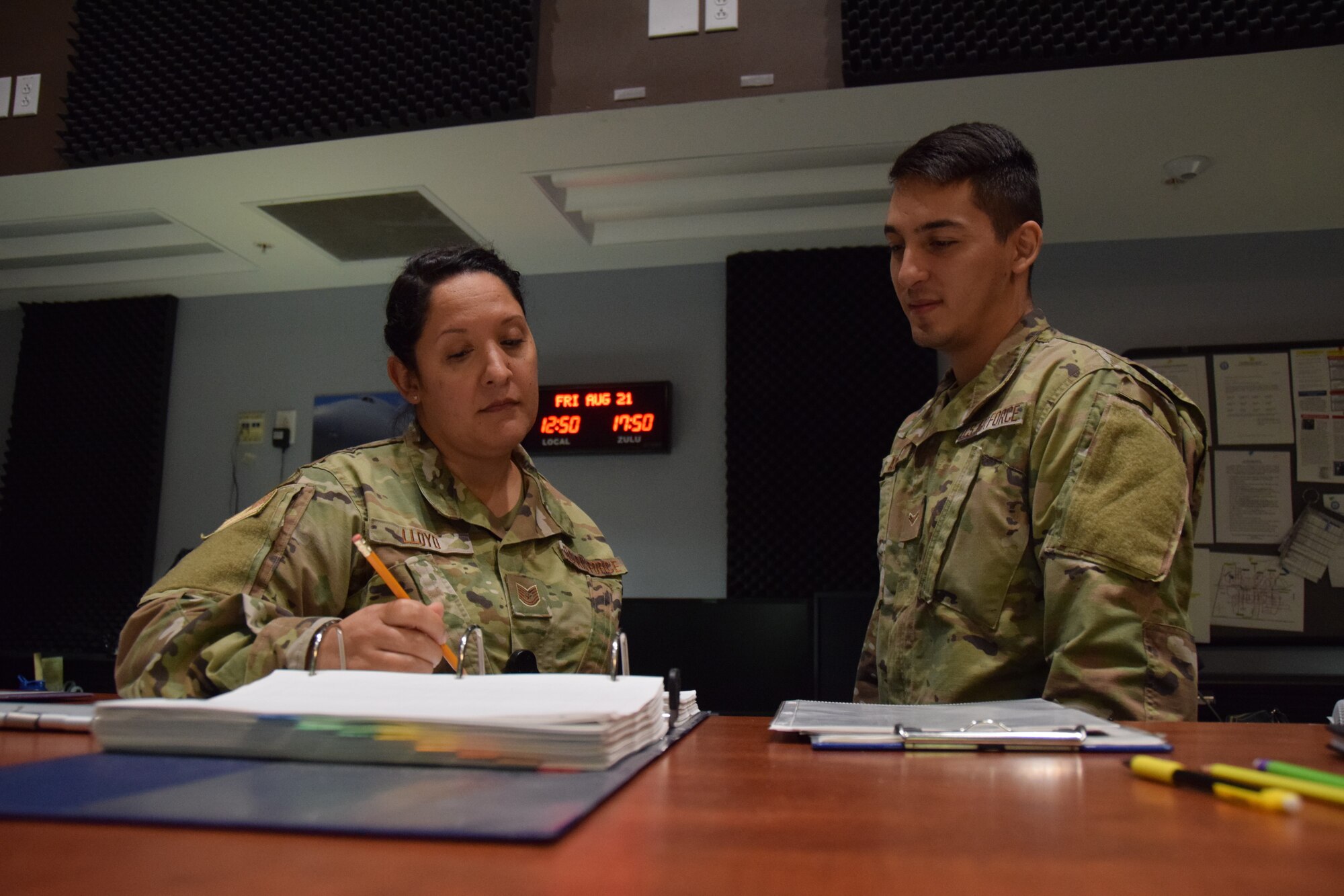 Tech. Sgt. Angela Lloyd and Airman 1st Class Jesus Alaniz, 433rd Airlift Wing Command Post controllers at Joint Base San Antonio-Lackland, Texas, review flight documentation for the C-5M Super Galaxy aircraft that evacuated Travis Air Force Base, California Aug. 21, 2020.