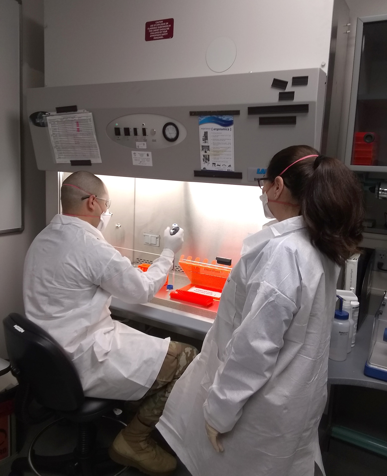 Spc. Darius Torres, a medical laboratory technician from Public Health Command-Pacific, simulates how to process a vector sample while Milagros Solá, a microbiologist form PHC-P, observes the process at the Environmental Molecular Biology Laboratory at Joint Base Lewis-McChord, Wash. Many of the procedures to process vector borne disease samples are similar to how clinic samples are processed for COVID-19, making Torres and Solá’s skill sets invaluable during the pandemic. (Courtesy photo)