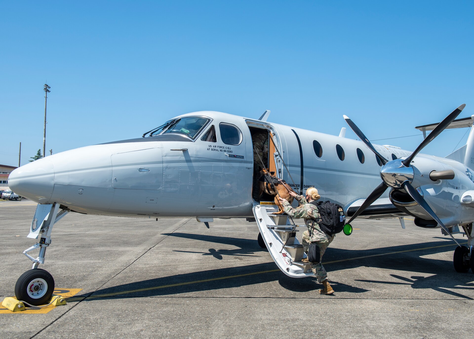 Staff Sgt. Ashleigh Green, 374th Security Forces Squadron military working dog handler, boards a C-12J Huron aircraft during a C-12J, K-9 evacuation training, August 20, 2020, at Yokota Air Base, Japan. Airmen from the 374th SFS and 18th Aeromedical Evacuation Squadron trained on K-9 evacuation procedures and best practices. (U.S. Air Force photo by Staff Sgt. Juan Torres)