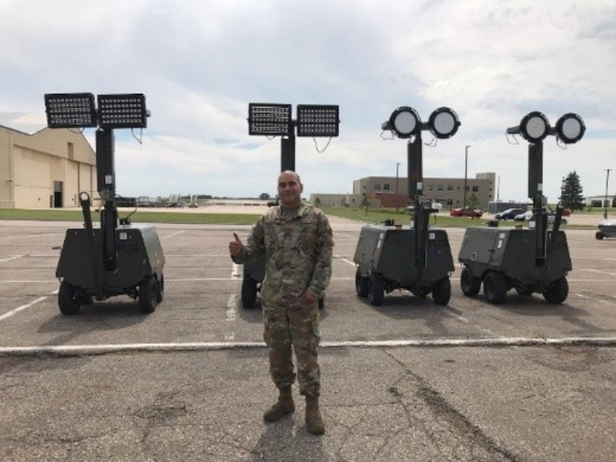 Air Force Global Strike Command 5th Maintenance Squadron AGE Section Chief, Master Sgt. Miguel Alvarez, in front of four flightline light carts retro-fitted with the two different LED fixture options for testing. (U.S. Air Force photo/Senior Airman Matthew Brown)