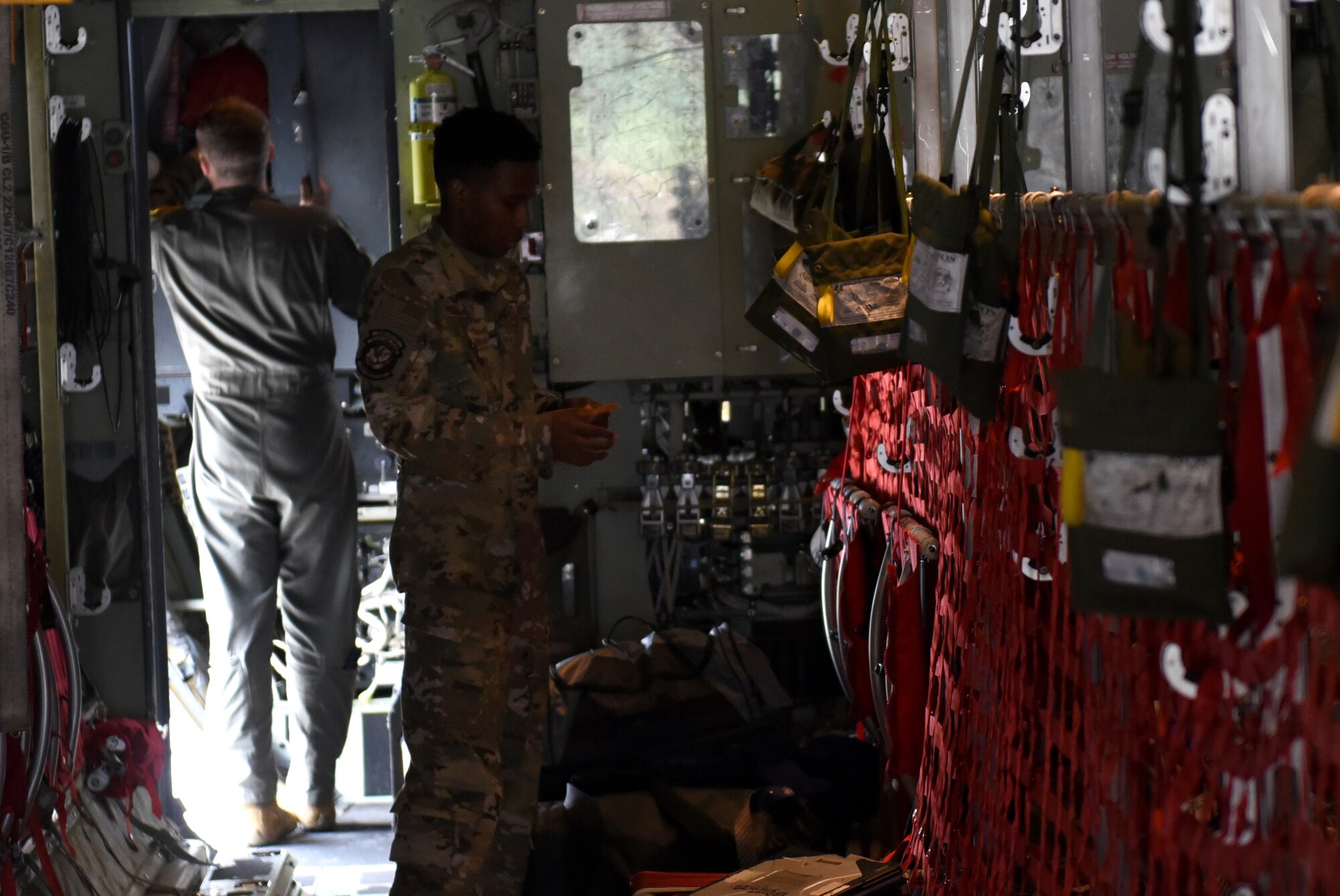Two men stand inside an aircraft