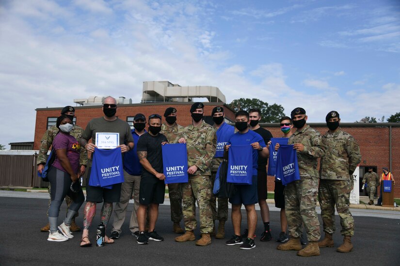 316th Security Forces Group Airmen pose for a photo before a 1.3-mile unity walk at Joint Base Andrews, Md., Sept. 3, 2020. Airmen held up their Unity Festival towels to show their support of the event. (U.S. Air Force photo by Airman 1st Class Spencer Slocum)