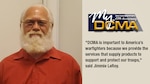 Man wearing a red shirt smiles at the camera. The My DCMA 20th anniversary logo is located in the right upper corner.