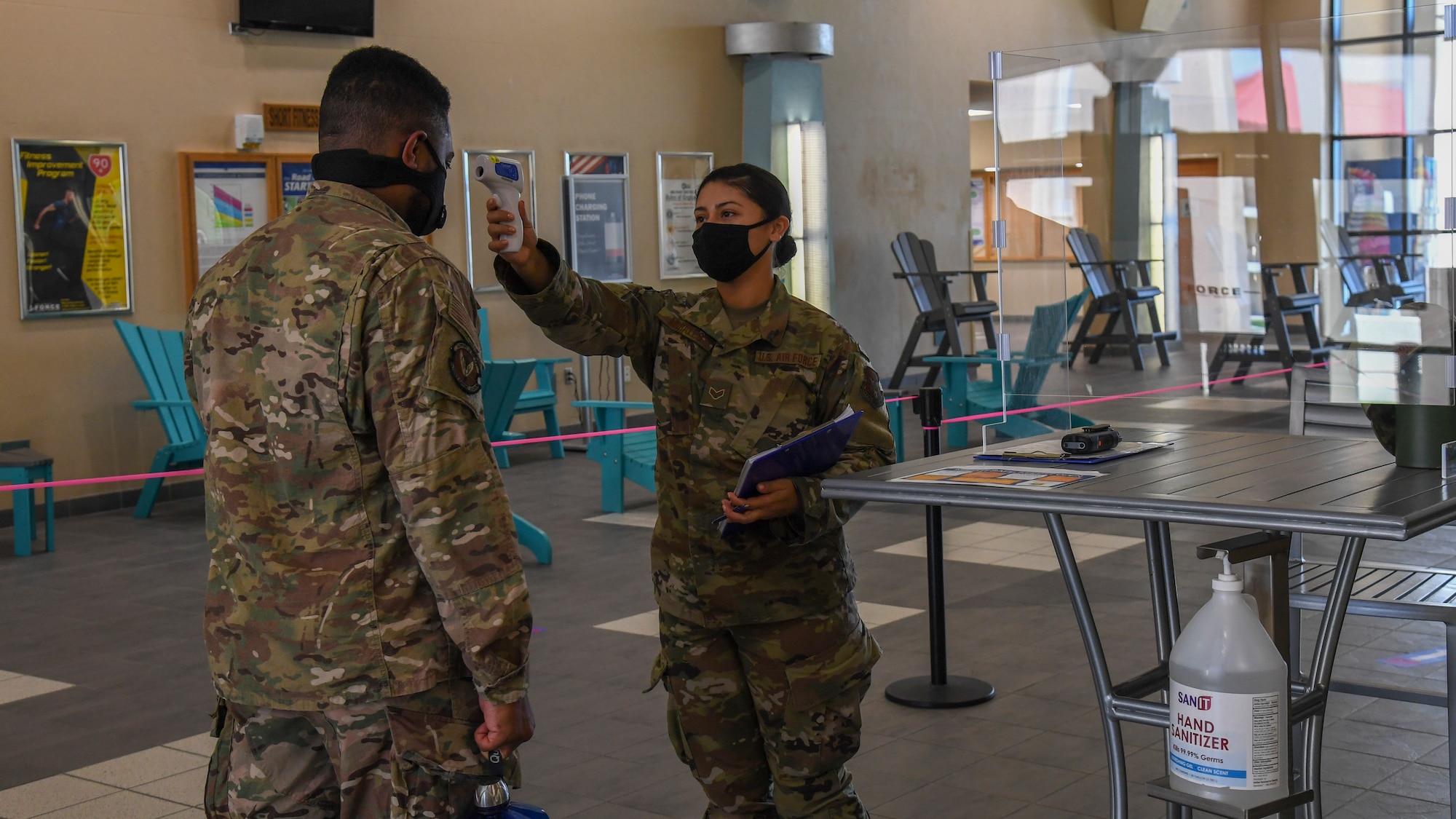 U.S. Air Force Senior Airman Esmeralda Morales, a 6th Force Support Squadron (FSS) fitness center specialist conducts a temperature check for Staff Sgt. Johari Stephens with the 6th FSS, as he enters the Short Fitness Center Sept. 2, 2020, at MacDill Air Force Base, Fla.