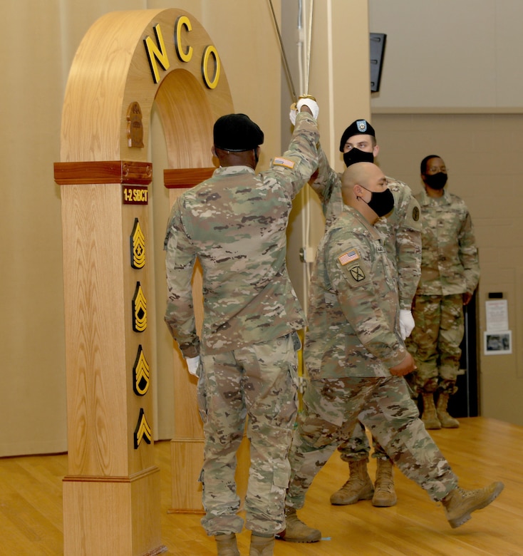Sgt. Victor Palomo, assigned to Company A, Troop Battalion, Madigan Army Medical Center, walks through the arch at the NCO induction ceremony at Joint Base Lewis-McChord, Wash., Aug. 7, 2020. (Photo Credit: Christopher Larsen)