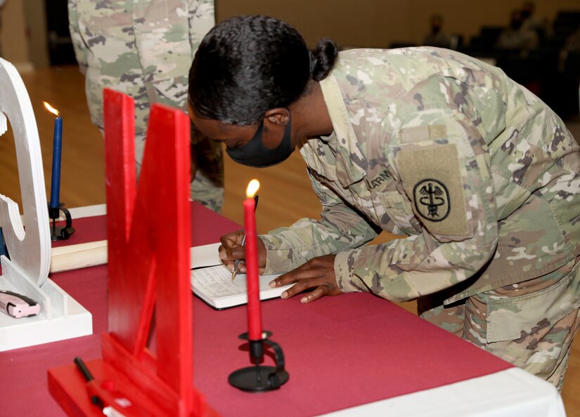 Staff Sgt. Perique Roseberry, assigned to Company A, Troop Battalion, Madigan Army Medical Center, Joint Base Lewis-McChord, signs the book at the NCO induction ceremony at JBLM, Aug. 7, 2020. (Photo Credit: Christopher Larsen)