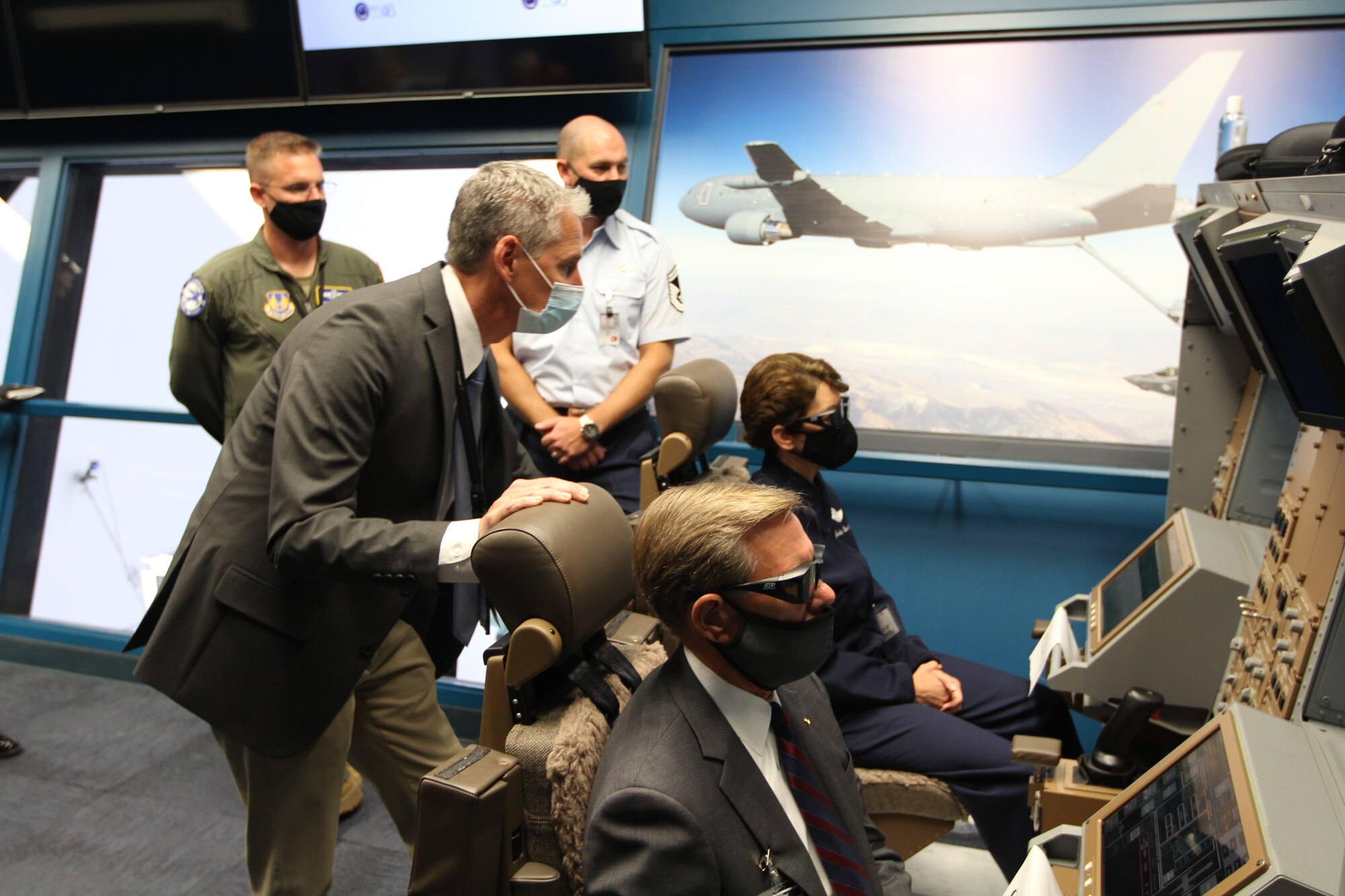Air Force Gen. Jacqueline Van Ovost, Air Mobility Command commander, back right, and Robert Behler, DOD Director of Operational Test and Evaluation, front right, get a demonstration of the enhanced remote vision system from Ernest Burns, Boeing KC-46 chief boom operator, front left, at Boeing Field, Tukwila, Washington, Sept. 4, 2020.
