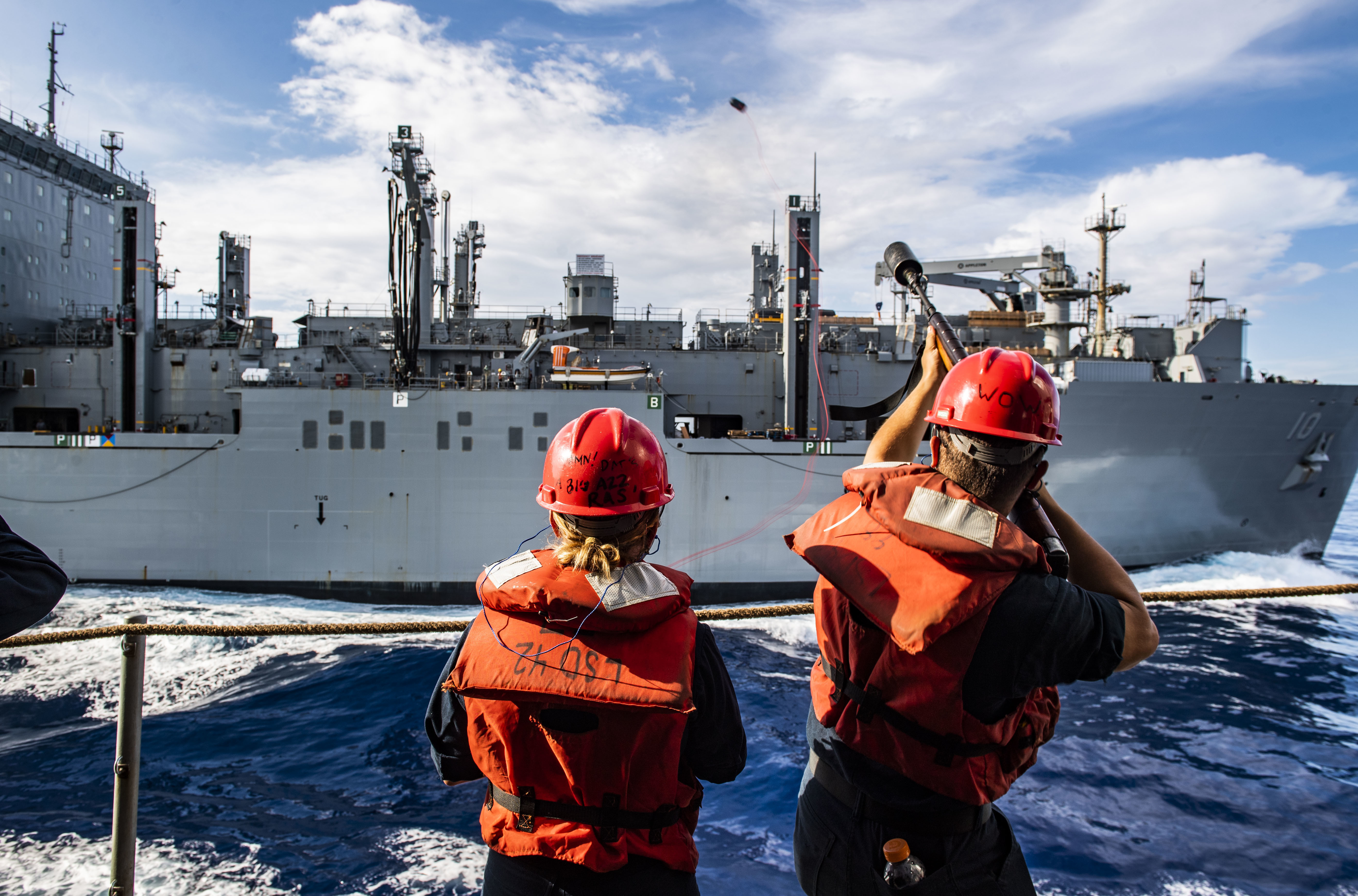 A Seaman fires a shot line from USS Germantown (LSD 42) to the dry cargo and ammunition ship USNS Charles Drew (T-AKE 10) as the ships conduct a replenishment-at-sea.