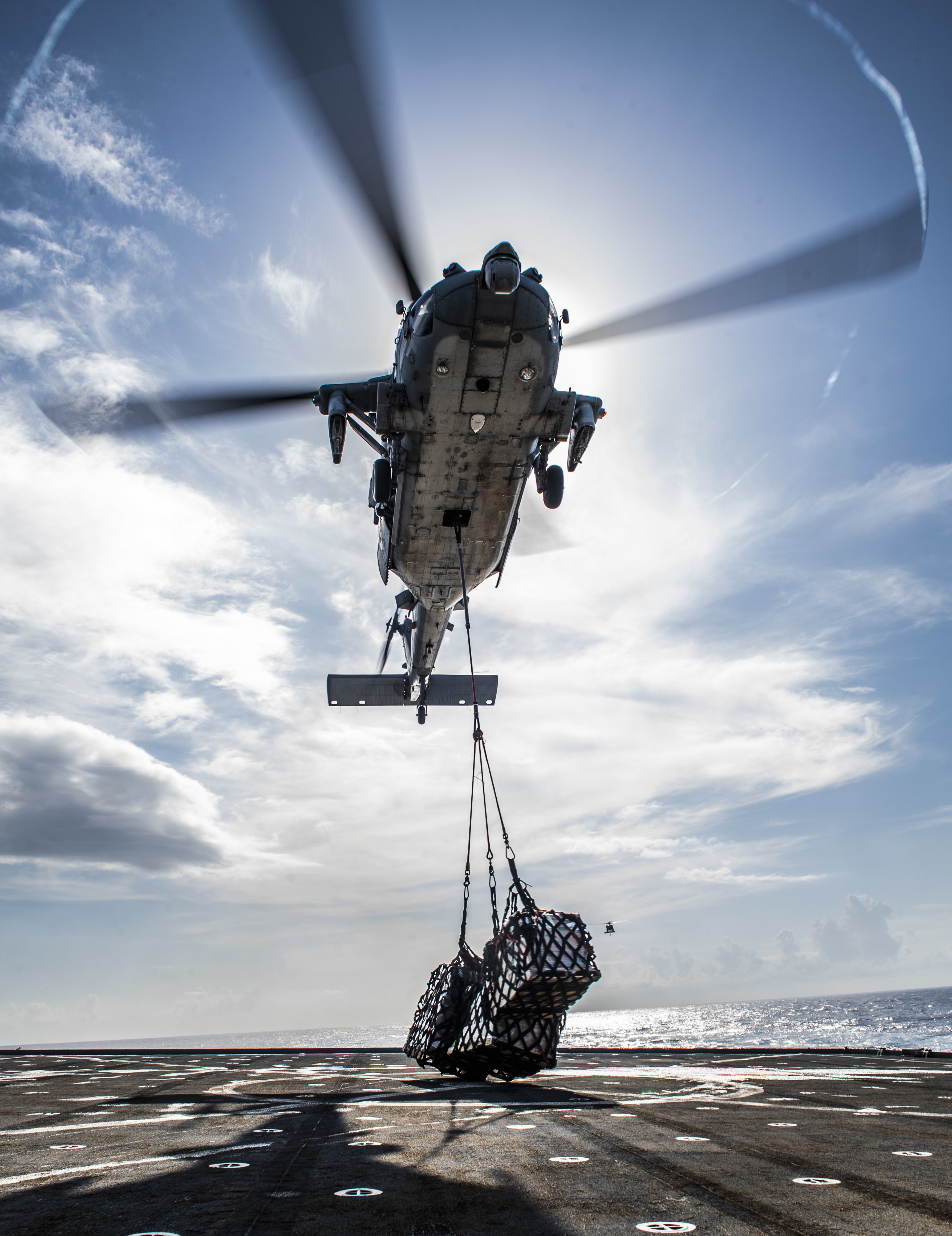 An MH-60S Sea Hawk helicopter from the “Archangels” of Helicopter Sea Combat Squadron (HSC) 25, Detachment 6, delivers stores to the flight deck of the amphibious dock landing ship USS Germantown (LSD 42)