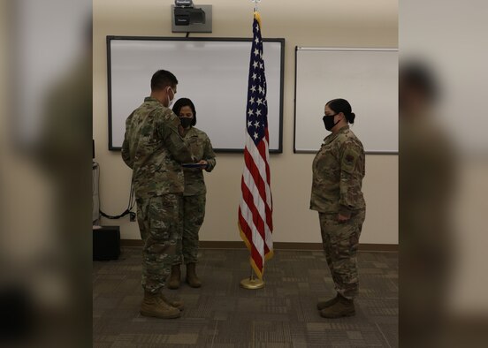 Col. Richard A. Goodman, 366th Fighter Wing commander, prepares to present the Bronze Medal award to Capt. Kristen Miranda, 366th Force Support Squadron operations officer, August 20, 2020, at Mountain Home Air Force Base. Miranda served as the director of operations for the 405th Expeditionary Support Squadron at Bagram Airfield, Afghanistan, from April 2019 to April 2020. (U.S. Air Force Photo courtesy of Shelly Turner)