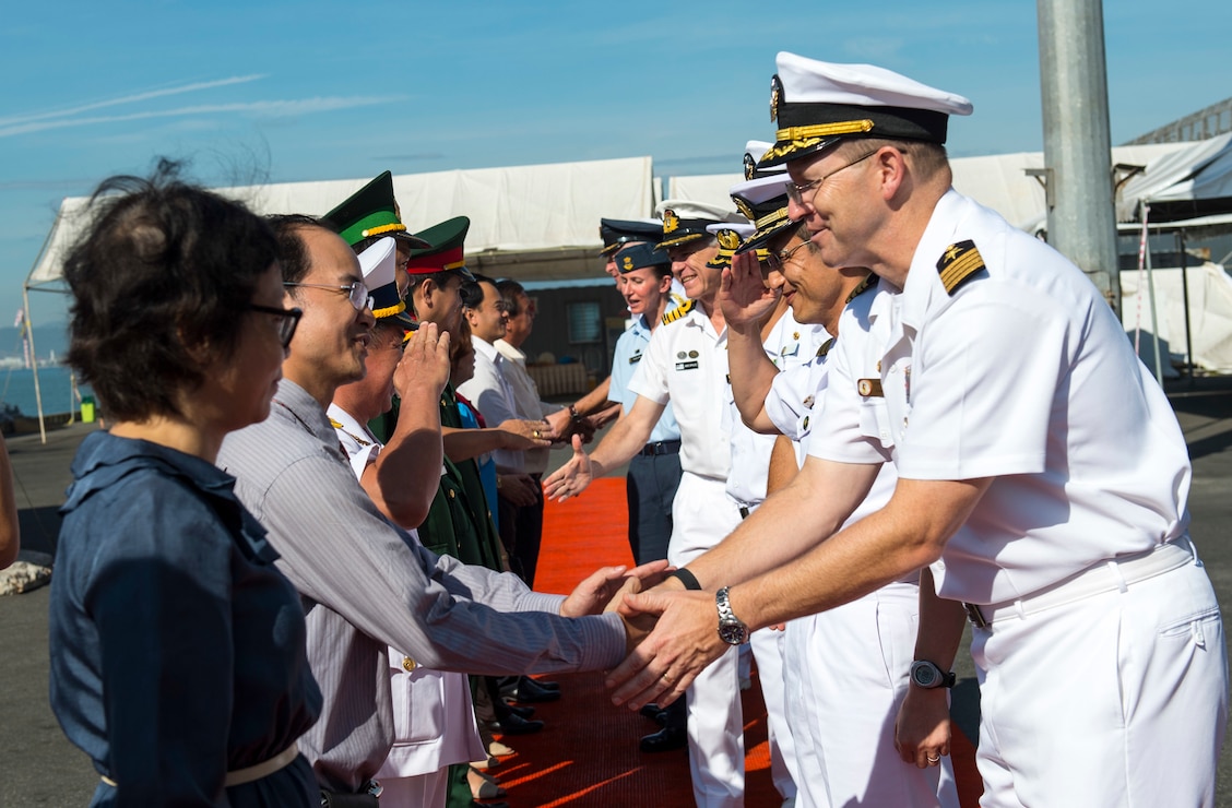 Commander and sailors shaking hands with authorities