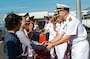 Commander and sailors shaking hands with authorities