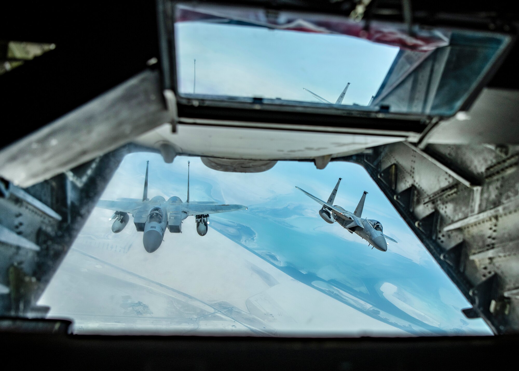 Two U.S. F-15Cs from Prince Sultan Air Base, Kingdom of Saudi Arabia fly behind a KC-10 Extender assigned to the 908th Expeditionary Air Refueling Squadron, 380th Air Expeditionary Wing during a large force employment, Aug 25, 2020, at Al Dhafra Air Base, United Arab Emirates.