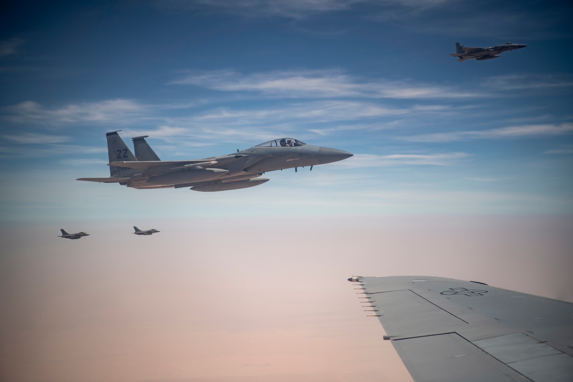 Two U.S. F-15C Eagles from 44th Expeditionary Fighter Squadron, Prince Sultan Air Base, Kingdom of Saudi Arabia (foreground) and two French Rafales fly along a KC-10 Extender assigned to the 908th Expeditionary Air Refueling Squadron, 380th Air Expeditionary Wing during a large force employment at Al Dhafra Air Base, United Arab Emirates Aug. 25, 2020.