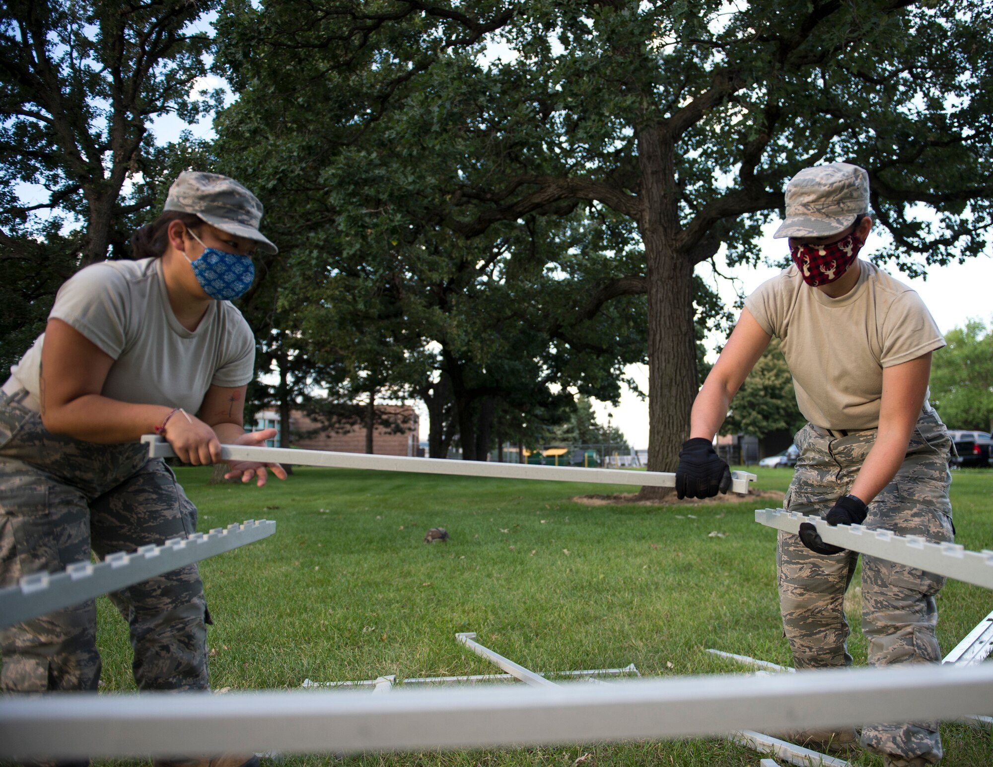 U.S. Air Force Airman 1st Class Soumina Yang, left, and Senior Airman Daisy Johnson, right, 133rd Sustainment Services Flight, assembly the plastic tray cart for the Single Pallet Expeditionary Kitchen (SPEK) in St. Paul, Minn., Aug. 20, 2020.