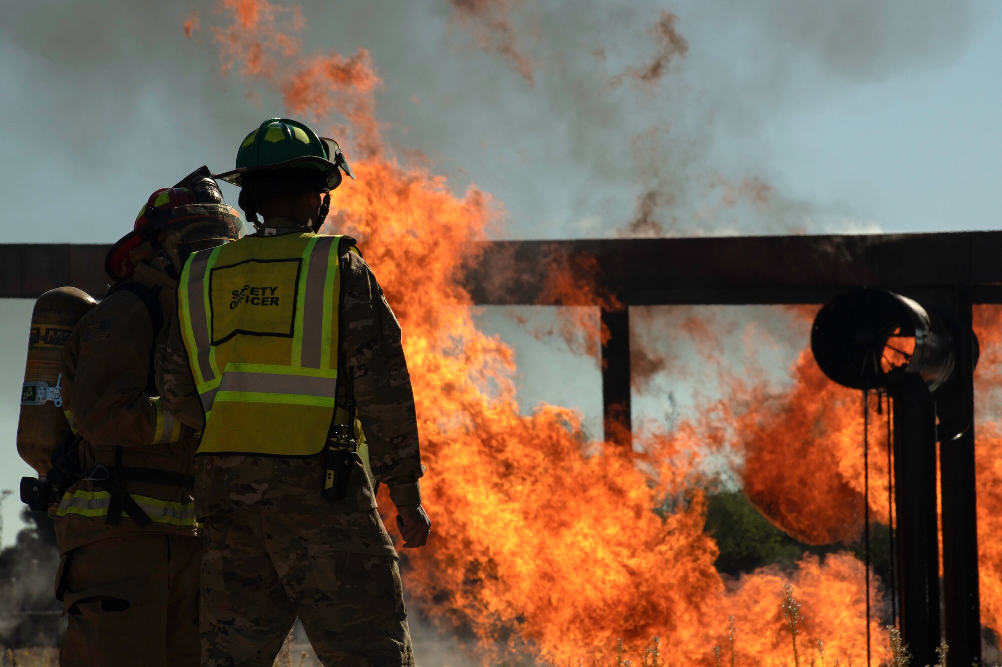 Picture of two Airmen talking with fire burning in background