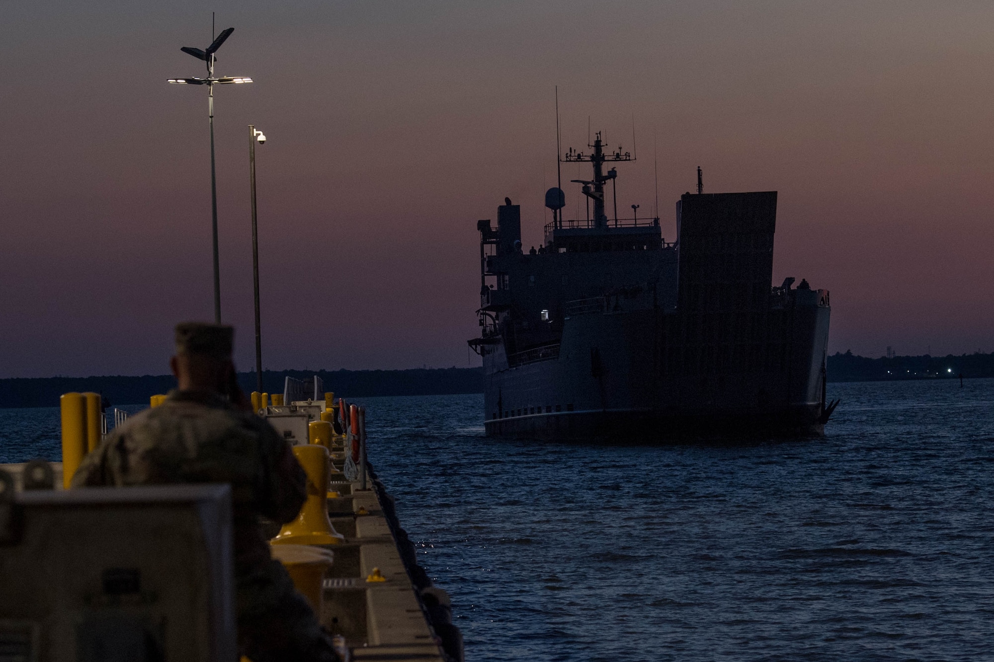 A Soldier watches a ship pull into Third Port.