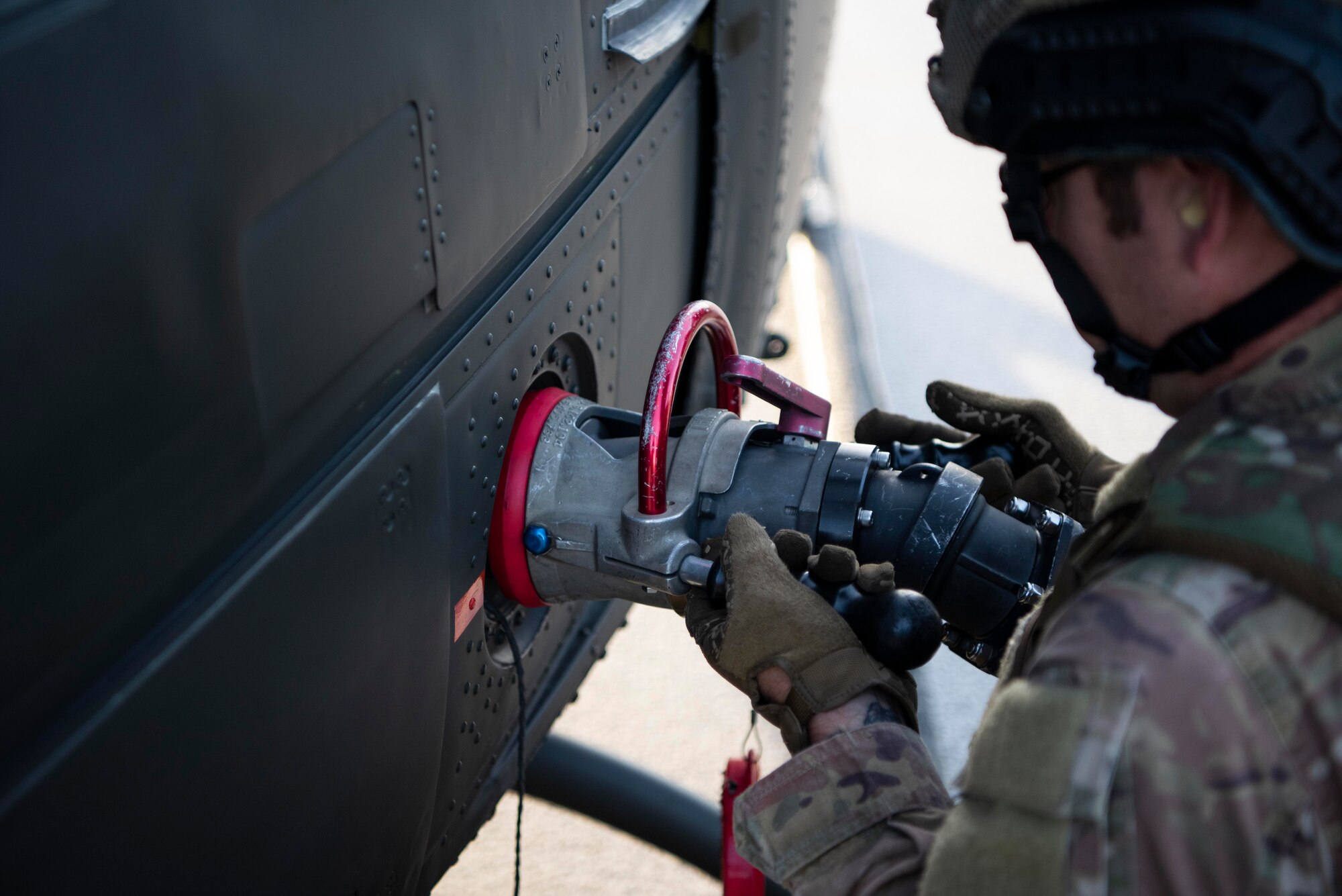 A forward area refueling point specialist with the U.S. Air Force 100th Logistics Readiness Squadron,  attaches a fuel hose to a Royal Norwegian Air Force Bell 412 helicopter during a training exercise at Rygge Air Station, Norway, August 26, 2020. Integration with the Norwegian Air Force allowed the 352d Special Operations Wing to enhance and strengthen bonds with our partner nation and further se-cure the strategic high-north region. The exercise provided training for 352d Special Operations Wing members on capabilities such as personnel recovery, forward area refueling point, aerial refueling, mari-time craft delivery system, and fast rope training. (U.S. Air Force photo by Staff Sgt. Michael Wash-burn)