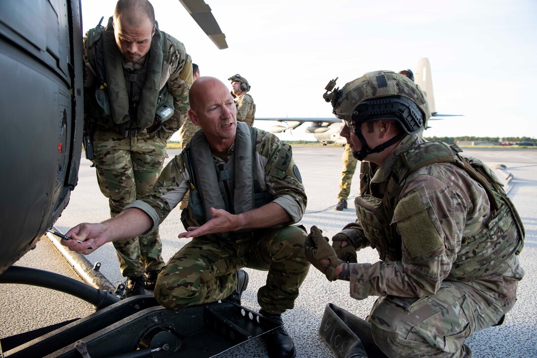 A Royal Norwegian Air Force Bell 412 helicopter crew member demonstrates refueling procedures with a U.S. Air Force 100th Logistics Readiness Squadron forward area refueling point specialist, during a training exercise at Rygge Air Station, Norway, August 26, 2020. Integration with the Norwegian Air Force allowed the 352d Special Operations Wing to enhance and strengthen bonds with our partner na-tion and further secure the strategic high-north region. The exercise provided training for 352d Special Operations Wing members on capabilities such as personnel recovery, forward area refueling point, aeri-al refueling, maritime craft delivery system, and fast rope training. (U.S. Air Force photo by Staff Sgt. Michael Washburn)