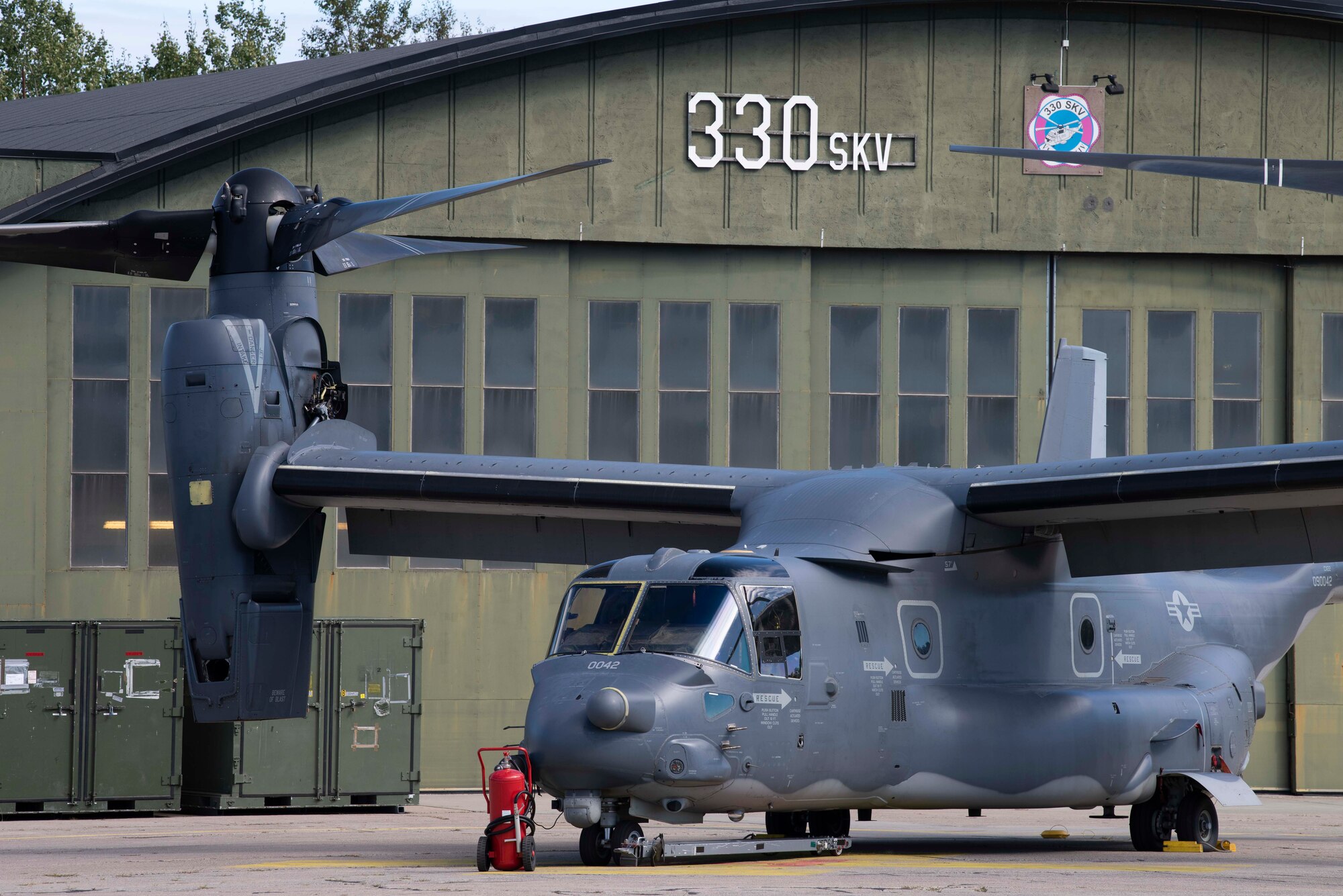 A CV-22B Osprey, based out of RAF Mildenhall, U.K., sits parked on the flightline outside a Norwe-gian hangar at Rygge Air Station, during a training mission, August 25, 2020. Integration with the Norwegian Air Force allowed the 352d Special Operations Wing to enhance and strengthen bonds with our partner nation and further secure the strategic high-north region. The exercise provided training for 352d Special Operations Wing members on capabilities such as personnel recovery, forward area refuel-ing point, aerial refueling, maritime craft delivery system, and fast rope training. (U.S. Air Force photo by Staff Sgt. Michael Washburn)