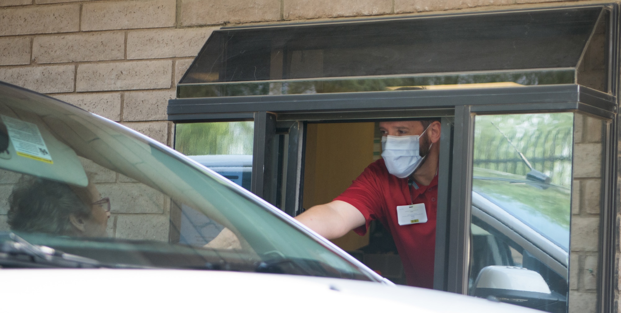 Mason Bushey, 56th Medical Group pharmacy technician, provides prescriptions through a drive-thru window Aug. 24, 2020, at Luke Air Force Base, Ariz.