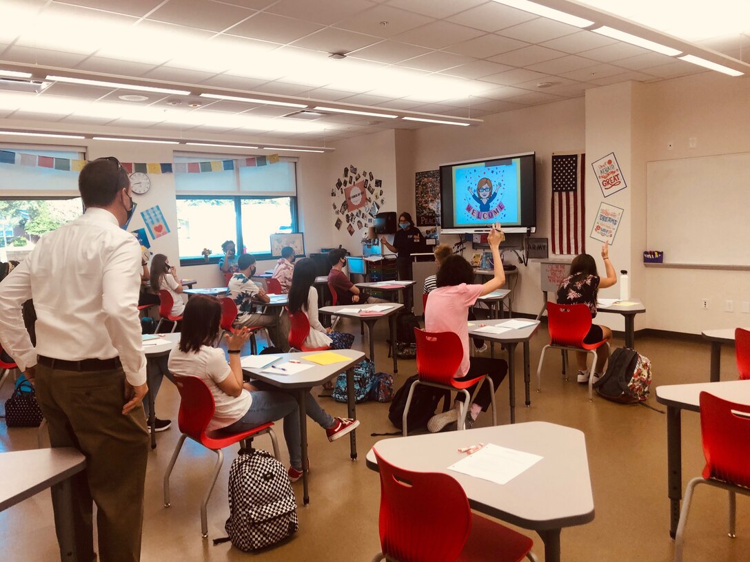 A teacher wearing a face mask teaches a class following COVID-19 social distancing guidelines.