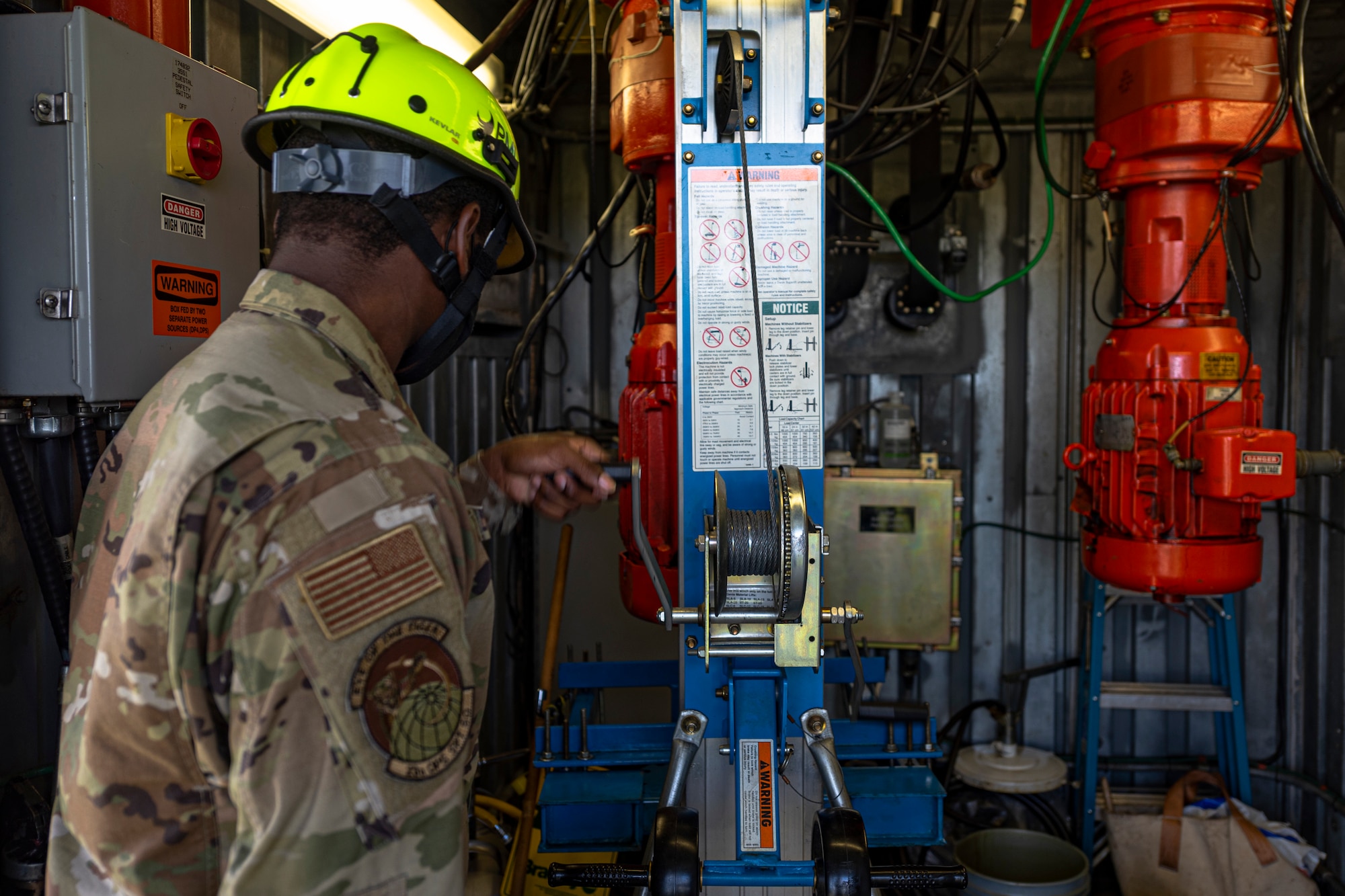 A photo of an Airman raising a motor lift