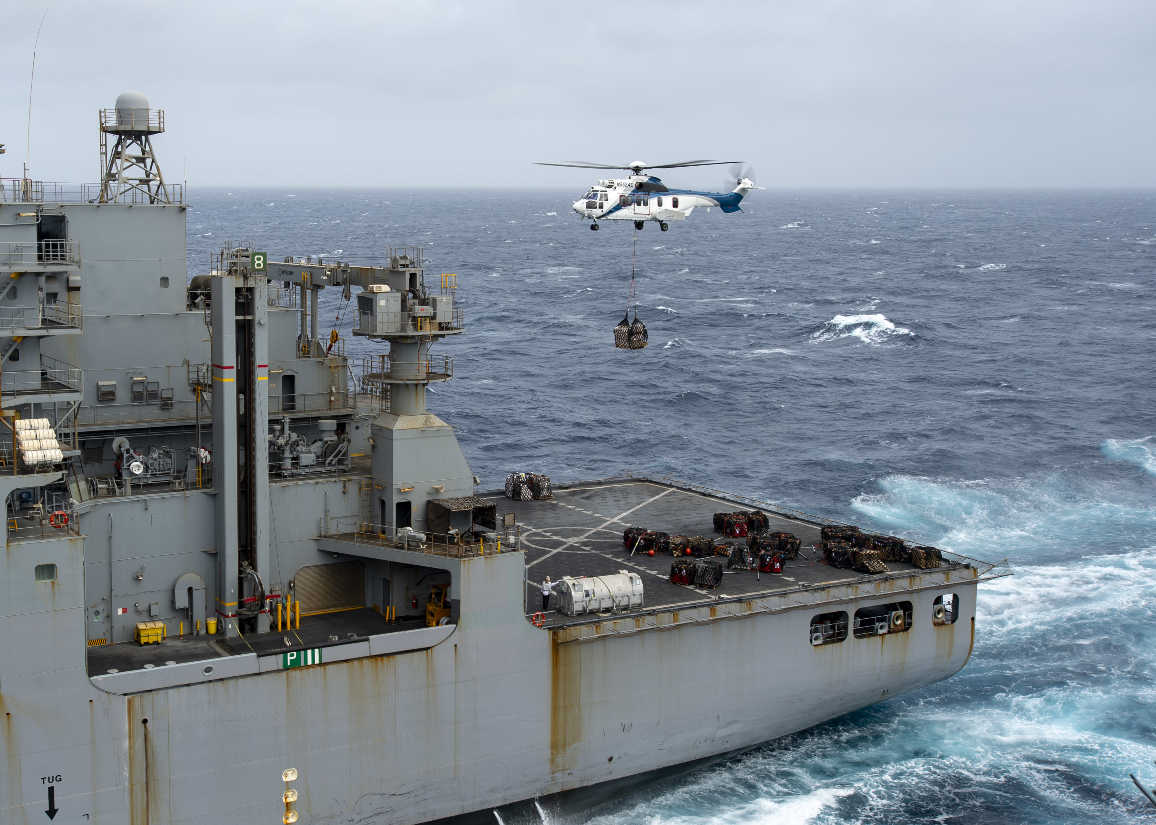 A Super Puma (EC-225) helicopter, attached to the Lewis and Clark-class dry cargo and ammunition ship USNS Amelia Earhart (T-AKE 6), moves pallets while conducting a replenishment-at-sea with the aircraft carrier USS Nimitz (CVN 68).