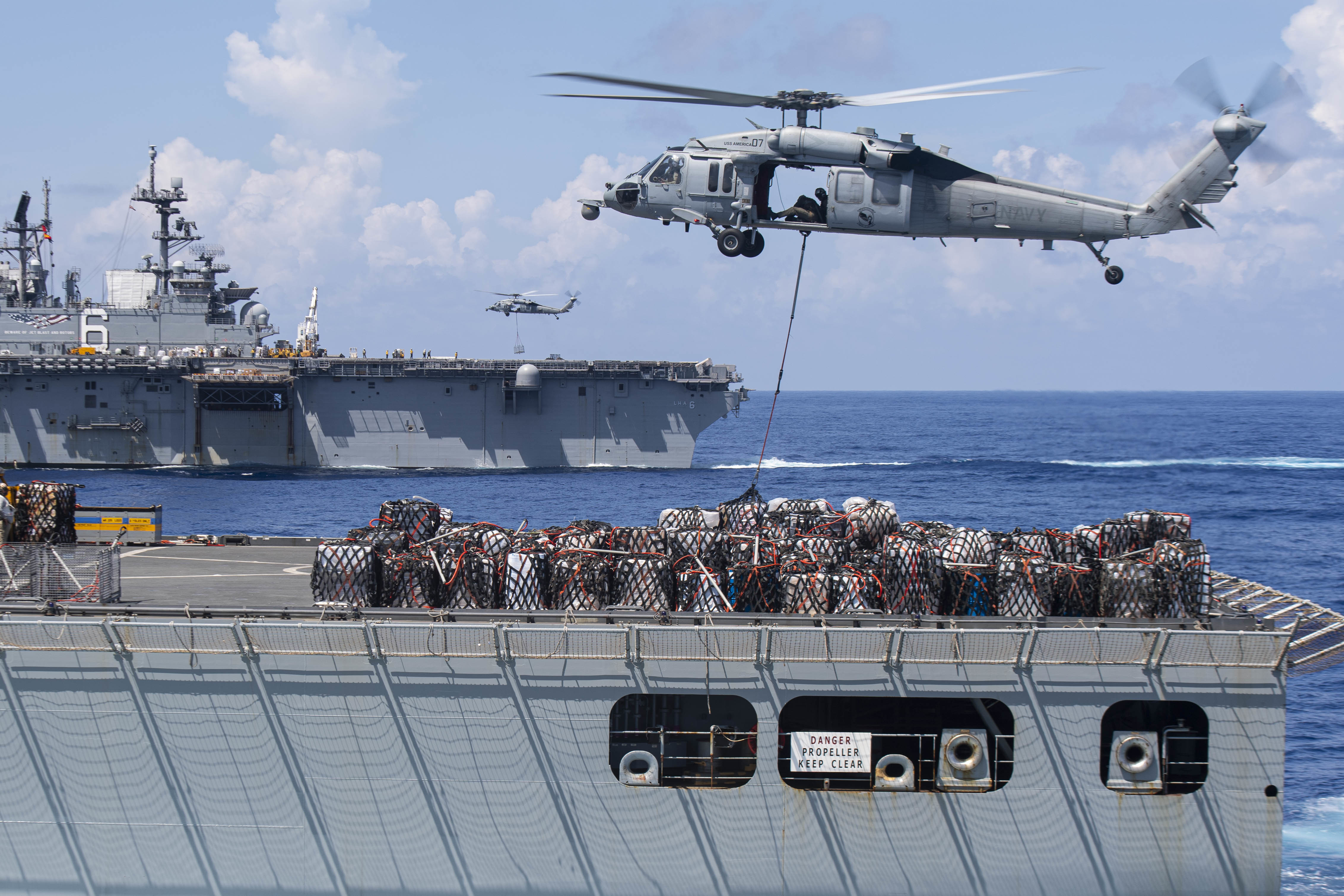USNS Charles Drew (T-AKE 10) and USS America (LHA 6) conduct an underway replenishment.