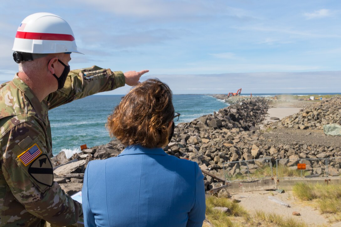 U.S. Army Col. Michael Helton, Portland District commander, highlights details of the South Jetty rehabilitation at the Mouth of the Columbia River to Congresswoman Suzanne Bonamici during a small commemoration event, Aug. 31. The Corps estimates that it will complete rehabilitation on South Jetty by 2024 and will use 400,000 tons of stone. The group, which included Senator Ron Wyden and Rep. Jaime Herrera Beutler, was able to see some of the work as contractors placed rock in the background. So far, the Corps has placed more than 14,000 tons of stone at South Jetty. (U.S. Army photo by Jeremy Bell)