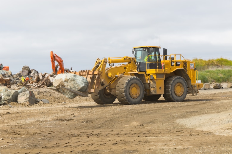 A construction crewmember moves a stone so excavators can place it on the South Jetty near Hammond, Ore., Aug. 31. The Portland District, U.S. Army Corps of Engineers has been rehabbing the jetty system for the last several years (completing work on Jetty “A” in 2018 and North Jetty in 2019) and just started work on South Jetty in June. On Aug. 31, the Corps, the Pacific Northwest Waterways Association (PNWA), the U.S. Coast Guard and several members of Congress gathered to commemorate that progress. (U.S. Army photo by Jeremy Bell)