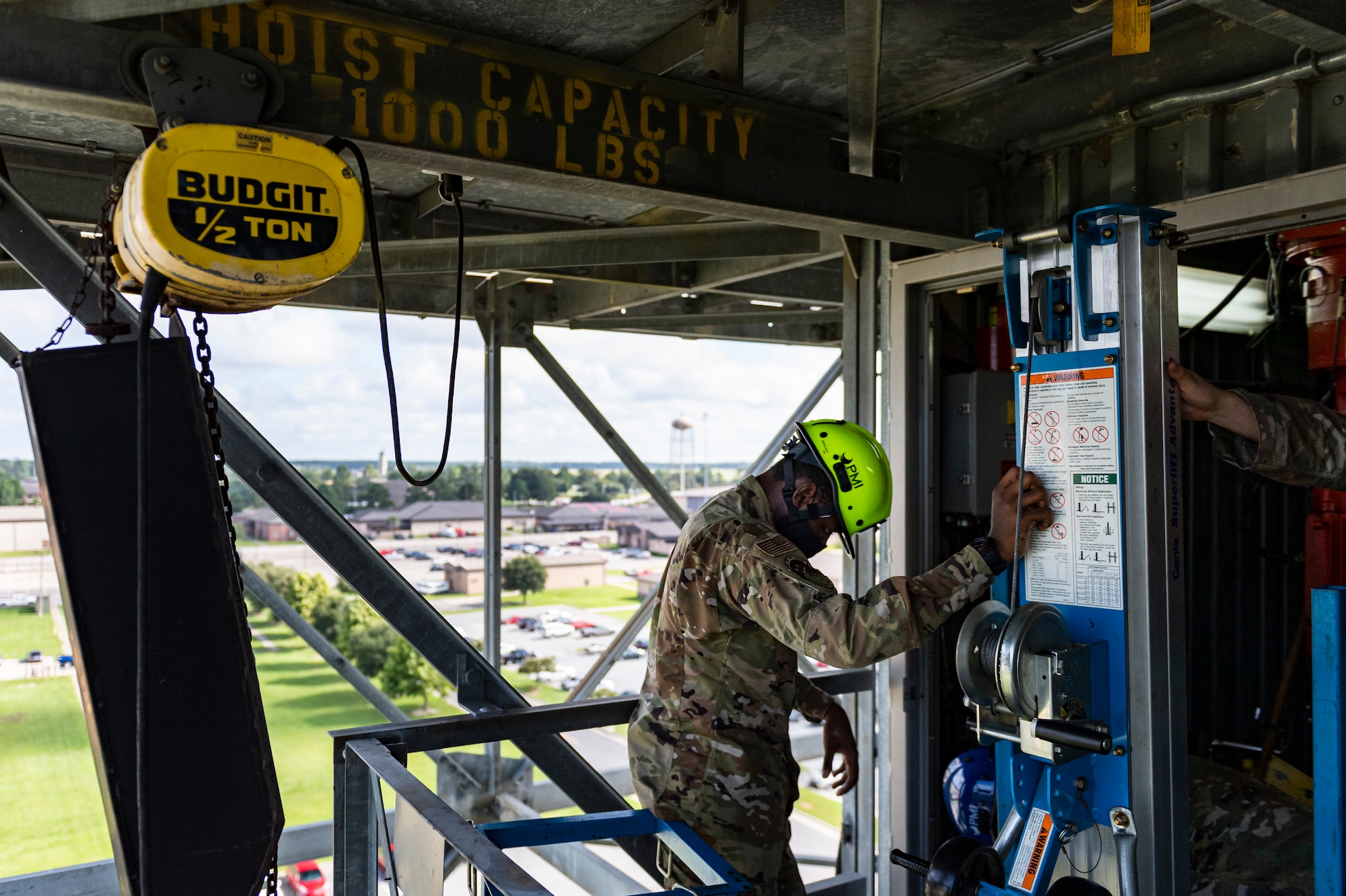 A photo of an Airman pulling out a motor lift from a room