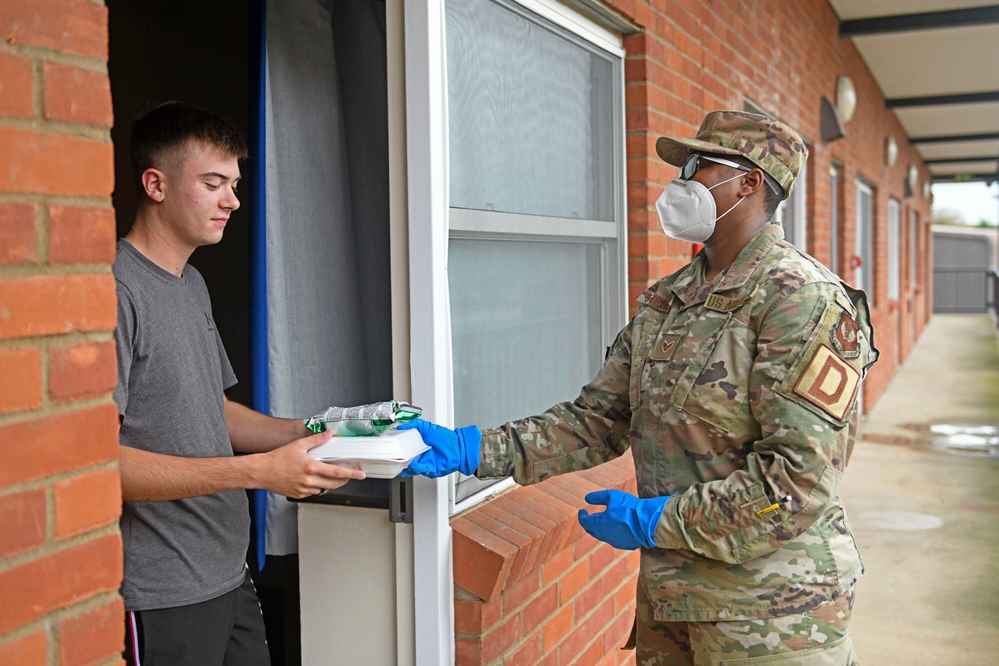 U.S. Air Force Senior Airman Nnkeha Streeter, 100th Maintenance Squadron aerospace ground equipment journeyman and Quarantine and Isolated Team member, delivers a meal to an Airman in quarantine at Royal Air Force Mildenhall, England, Sept. 3, 2020. The Qni Team preserves, supplies and supports the social, mental, physical and spiritual needs of Airmen and their families when quarantined. (U.S. Air Force photo by Staff Sgt. Mackenzie Mendez)