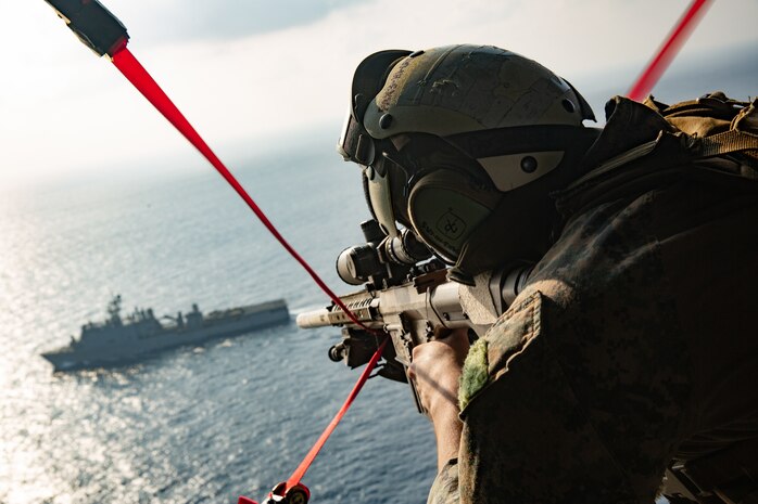 A U.S. Marine provides aerial security during a Visit Board Search and Seizure mission on a UH-1Y Venom helicopter with Marine Medium Tiltrotor Squadron 262, 31st MEU, after taking off from amphibious assault ship USS America (LHA 6).