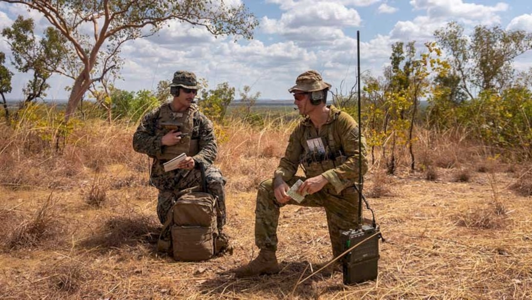 U.S. Marine Corps Staff Sgt. Micheal Mendoza, a joint terminal attack controller with Command Element, Marine Rotational Force - Darwin, left, and Australian Defence Force Sgt. Aaron Costas, with 102nd Coral Battery, communicate to a B-1B Lancer pilot at Mount Bundey Training Area, Northern Territory, Australia, Aug. 14, 2020. The combined training allowed both Marines and Australian Defence Force members to learn how to communicate effectively to be ready to work together to to contribute to regional security. (U.S. Marine Corps photo by Cpl. Sarah Marshall)