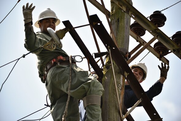 ech. Sgt. Chaz Lineberger and Senior Airman Cody McCormick 8th Civil Engineer Squadron electrical systems technicians, prepare a line for reattachment in response to Typhoon Maysak at Kunsan Air Base, Republic of Korea, Sept. 3, 2020.