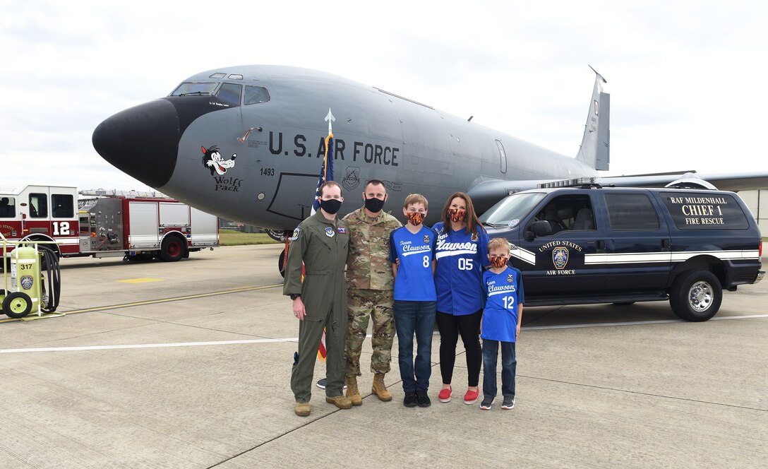 Chief Master Sgt. Travis Clawson, second left, 100th Civil Engineer Squadron installation fire chief, poses for a photo with his family and Capt. Anthony Caliva, 351st Air Refueling Squadron pilot, after his final reenlistment ceremony at Royal Air Force Mildenhall, England, Sept. 2, 2020. Clawson was previously an instructor at the U.S. Air Force Academy in Colorado Springs, Colorado, and was the recipient of Caliva’s “silver dollar salute” in 2012. (U.S. Air Force photo by Karen Abeyasekere)