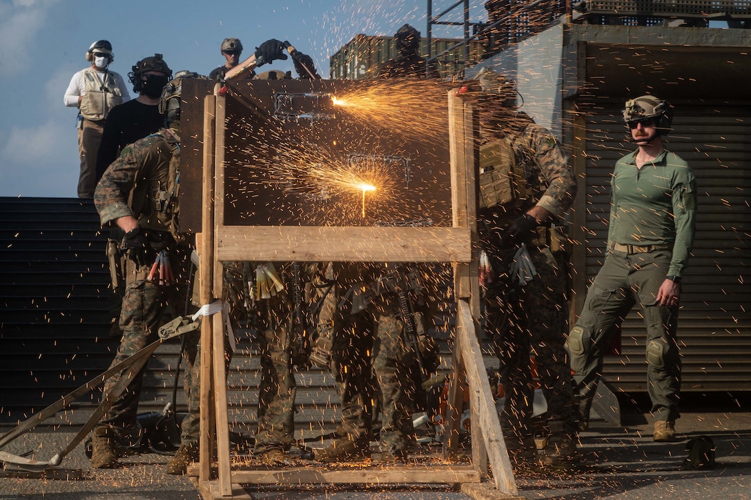 U.S. Marines cut through a metal plate during a simulated visit, board, search, and seizure mission aboard dock landing ship USS Germantown (LSD 42), Sept. 6.