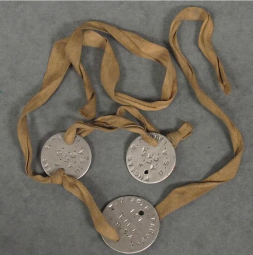 Three medal disks are each tied with a length of twill rope.