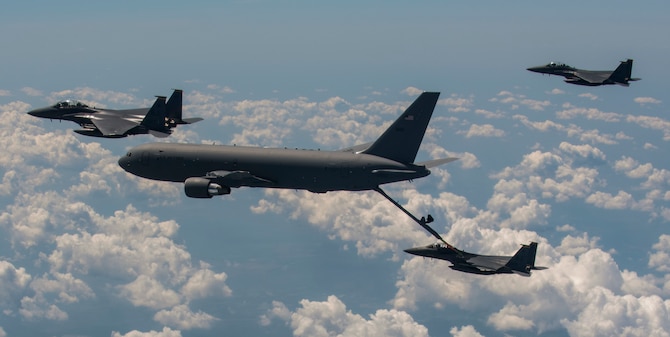 A KC-46 Pegasus from the 916th Air Refueling Wing in-air refuels F-15E Strike Eagles from the 336th Fighter Squadron at Seymour Johnson Air Force Base over the sky of North Carolina.