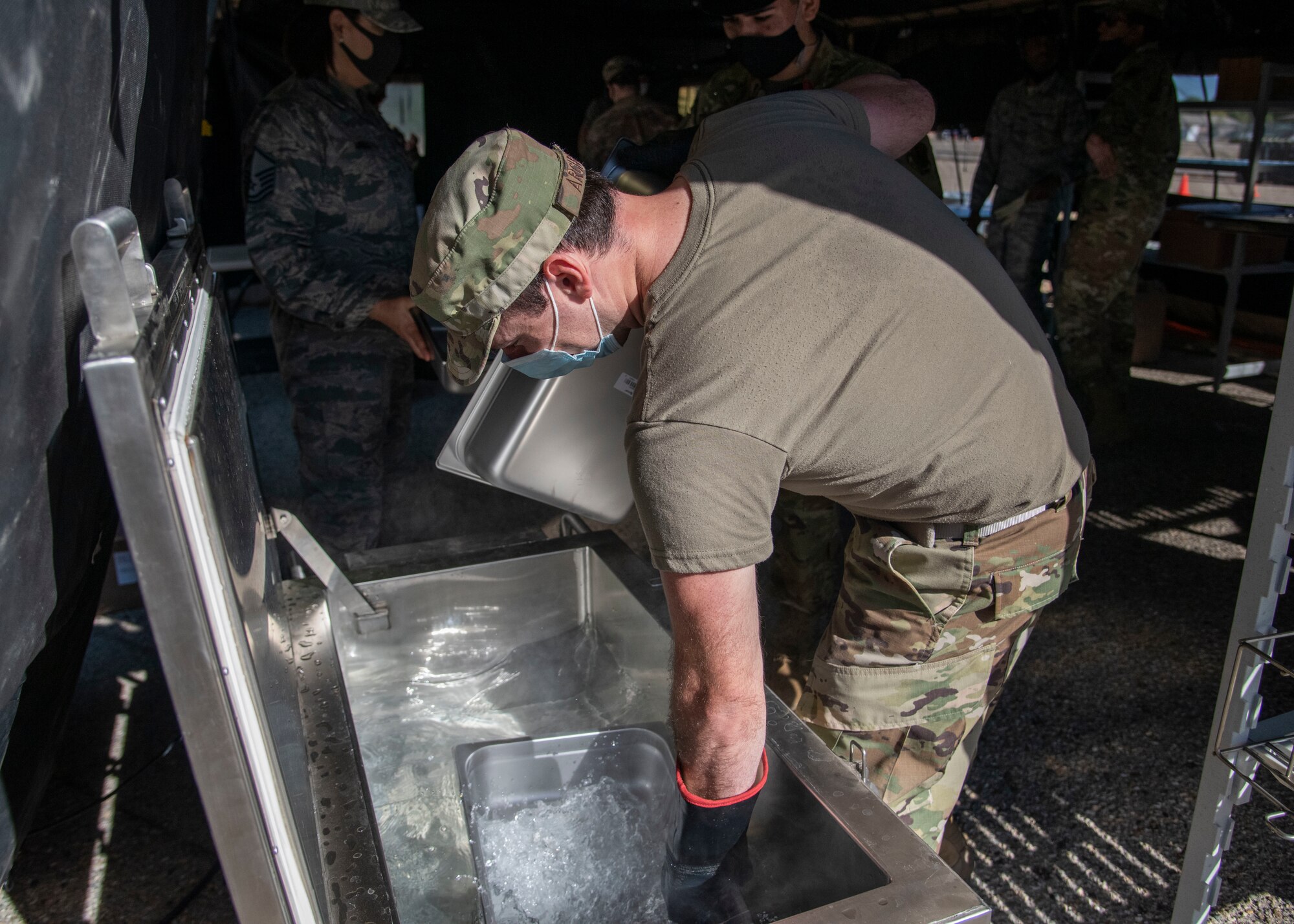 Airmen from the 366th Force Support Squadron rinse pans for a Unitized Group Ration during a training exercise, Sept. 4, 2020, on Mountain Home Air Force Base, Idaho. The training is part of an annual pallet expeditionary kitchen set up exercise. (U.S. Air Force photo by Airman Andrea Rozoto)