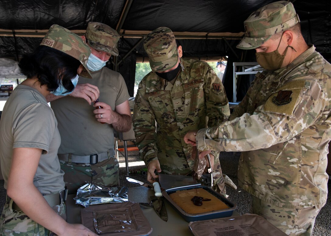 Airmen from the 366th Force Support Squadron prepare a Unitized Group Ration during a training exercise, Sept. 4, 2020, on Mountain Home Air Force Base, Idaho. The training is part of an annual pallet expeditionary kitchen set up exercise. (U.S. Air Force photo by Airman Andrea Rozoto)