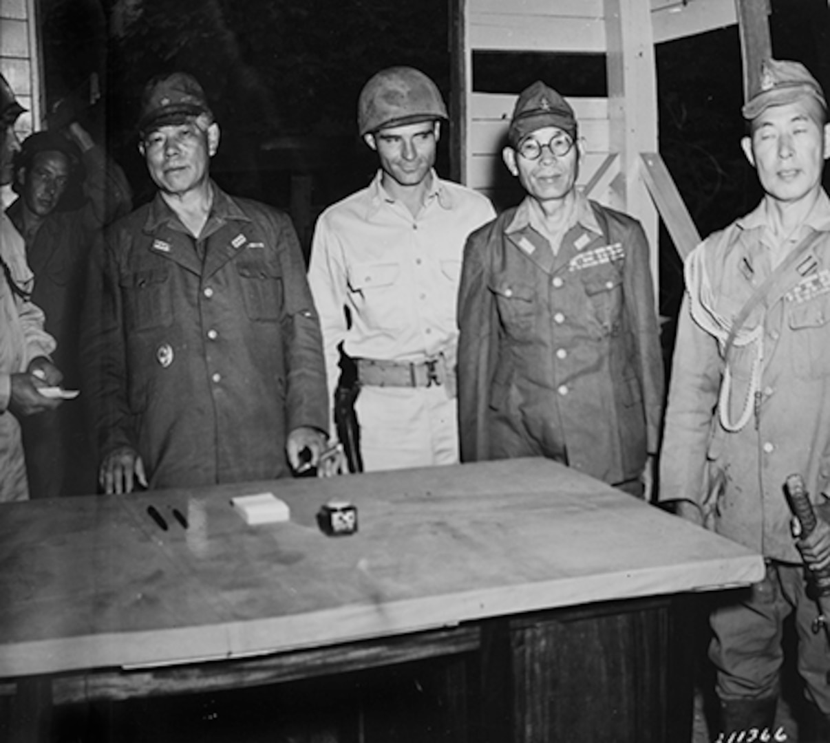 Defiant to the very end and refusing to capitulate until Japan formally surrendered in Tokyo, Gen. Tomoyuki Yamashita, commander of all Japanese forces in the Philippines, is shown Sept. 2, 1945, as he surrenders the battered remnants of his once-formidable forces to the 32nd “Red Arrow” Division at Kiangan in northern Luzon, Philippine Islands. From left to right: Col. Ernest Barlow, 32nd Division chief of staff; Gen. Tomoyuki Yamashita; Lt. Col. Alex Robinet, 128th Infantry Regiment executive officer; and two members of Yamashita’s staff. Yamashita signed surrender documents the following day.