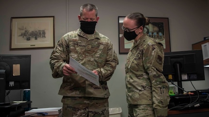 Senior Master Sgt. Christopher Haney and Master Sgt. Rebekah Schroeder look over a report at Joint Base Langley-Eustis, Virginia, July 22, 2020.