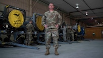 Senior Master Sgt. Christopher Haney poses in front of jet engines at Joint Base Langley-Eustis, Virginia, July 22, 2020.