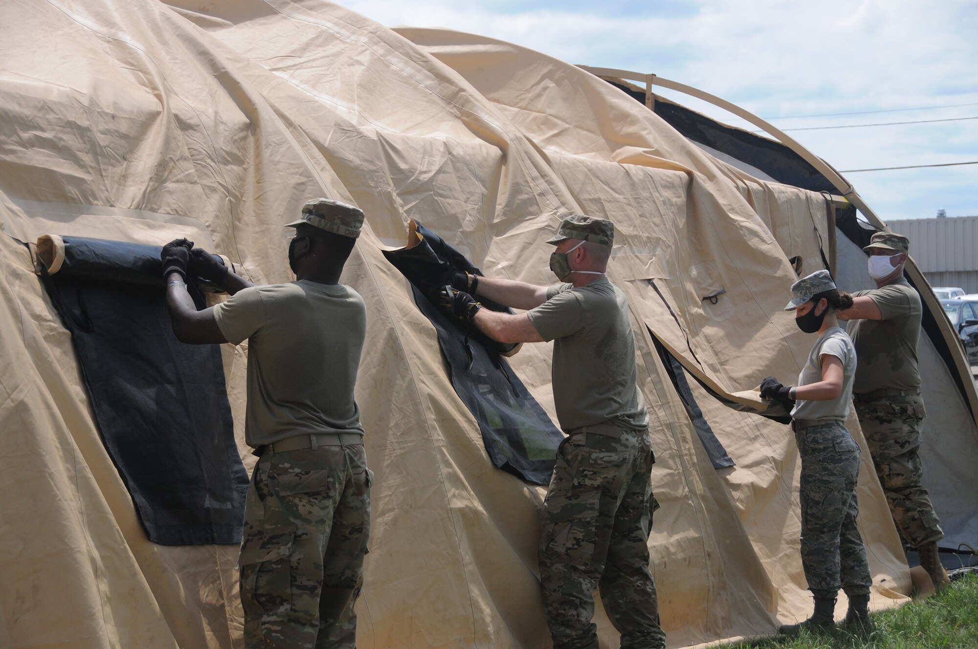 Airmen from the 445th Aeromedical Staging Squadron work together during a training event to build a tent that will act as a staging ground for patients before they are transported out to the flightlline and flown to a hospital.