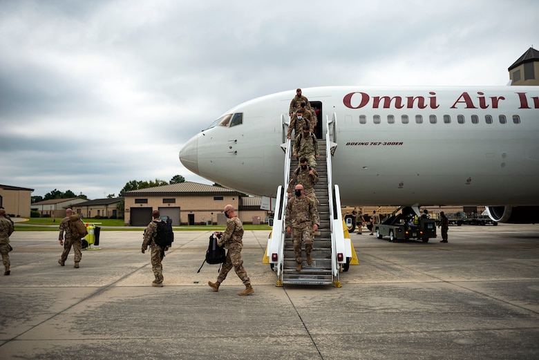 Photo of Airmen exiting an aircraft.