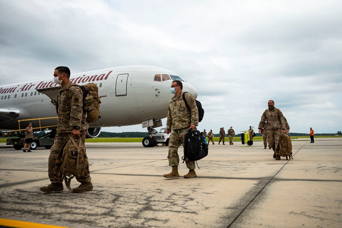 Photo of Airmen exiting an aircraft.